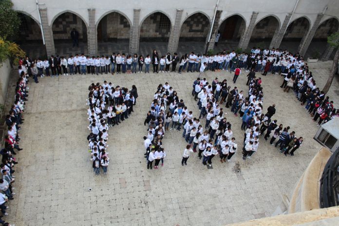 Zdj. ACN International / Dzieci w szkole w Damaszku, Syria, tworzą napis "PAX" = pokój